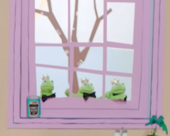 One can in front of the frog puppets.